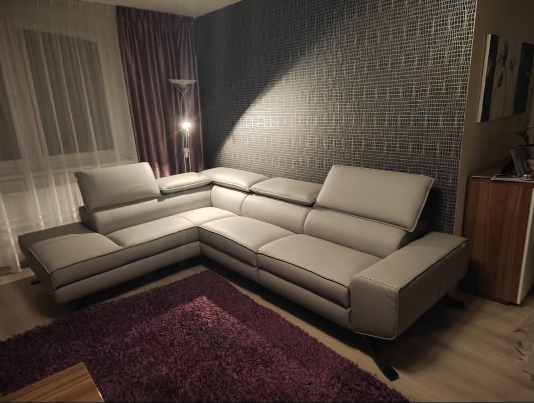 Rohová kožená pohovka 306 × 225 cm v obývacím pokoji střední velikosti.